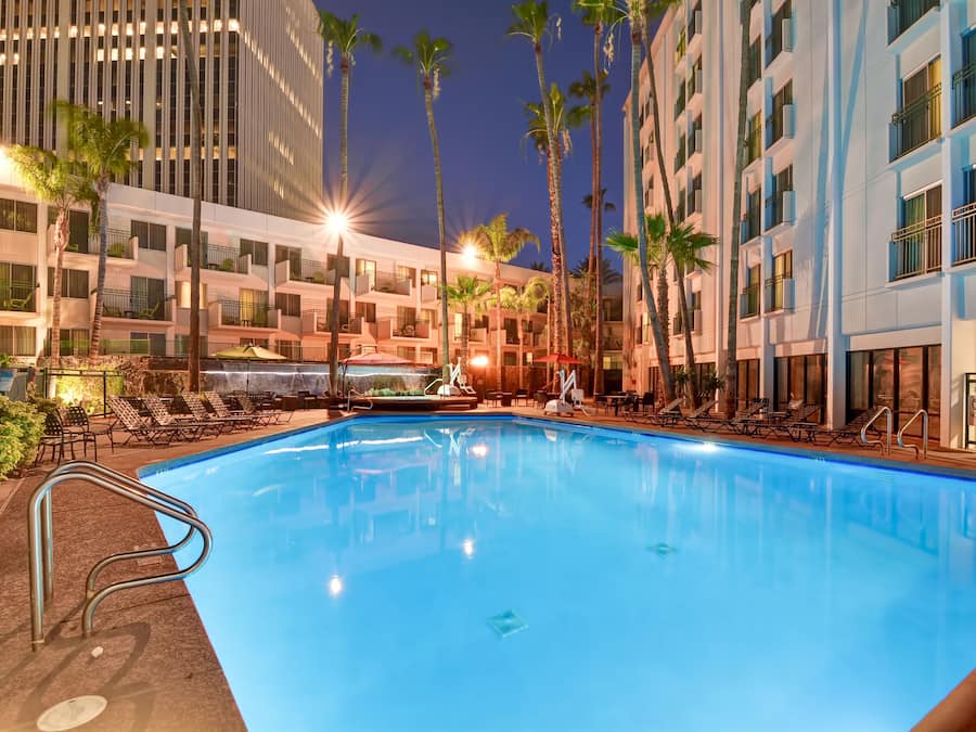 Een buitenzwembad, ligstoelen bij het zwembad