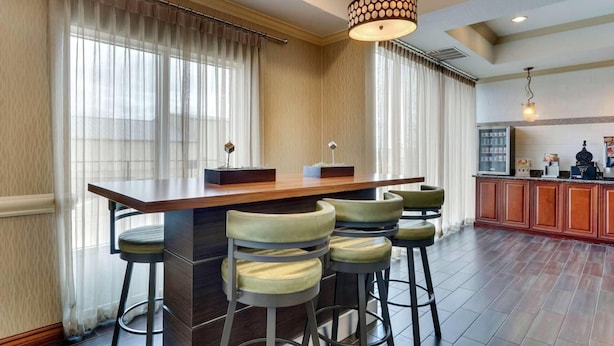 A bar area with a wooden counter, bar stools, and pendant lighting. - Comfort Inn & Suites Waco Woodway (Waco)