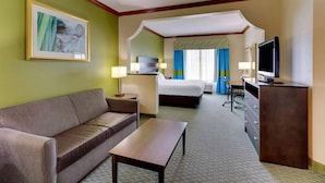 A hotel room with a sofa, a small table, a bed, a TV, and a desk. - Comfort Inn & Suites Waco Woodway (Waco)