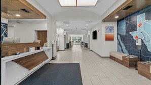 A modern reception area with a desk, seating, and a map mural on the wall. - Holiday Inn Express Crockett by IHG (Crockett)