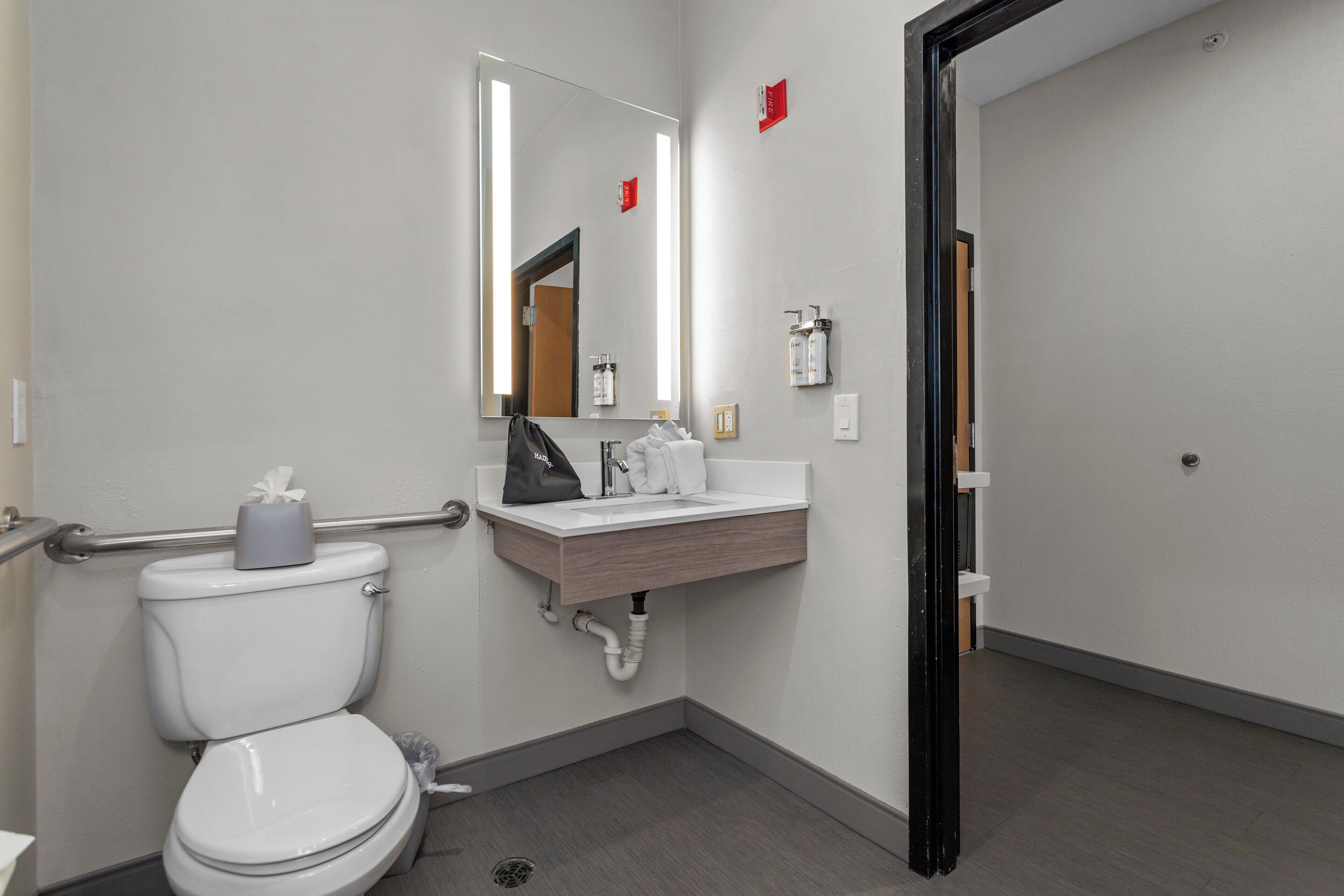 A modern bathroom with a toilet, sink, and mirror.