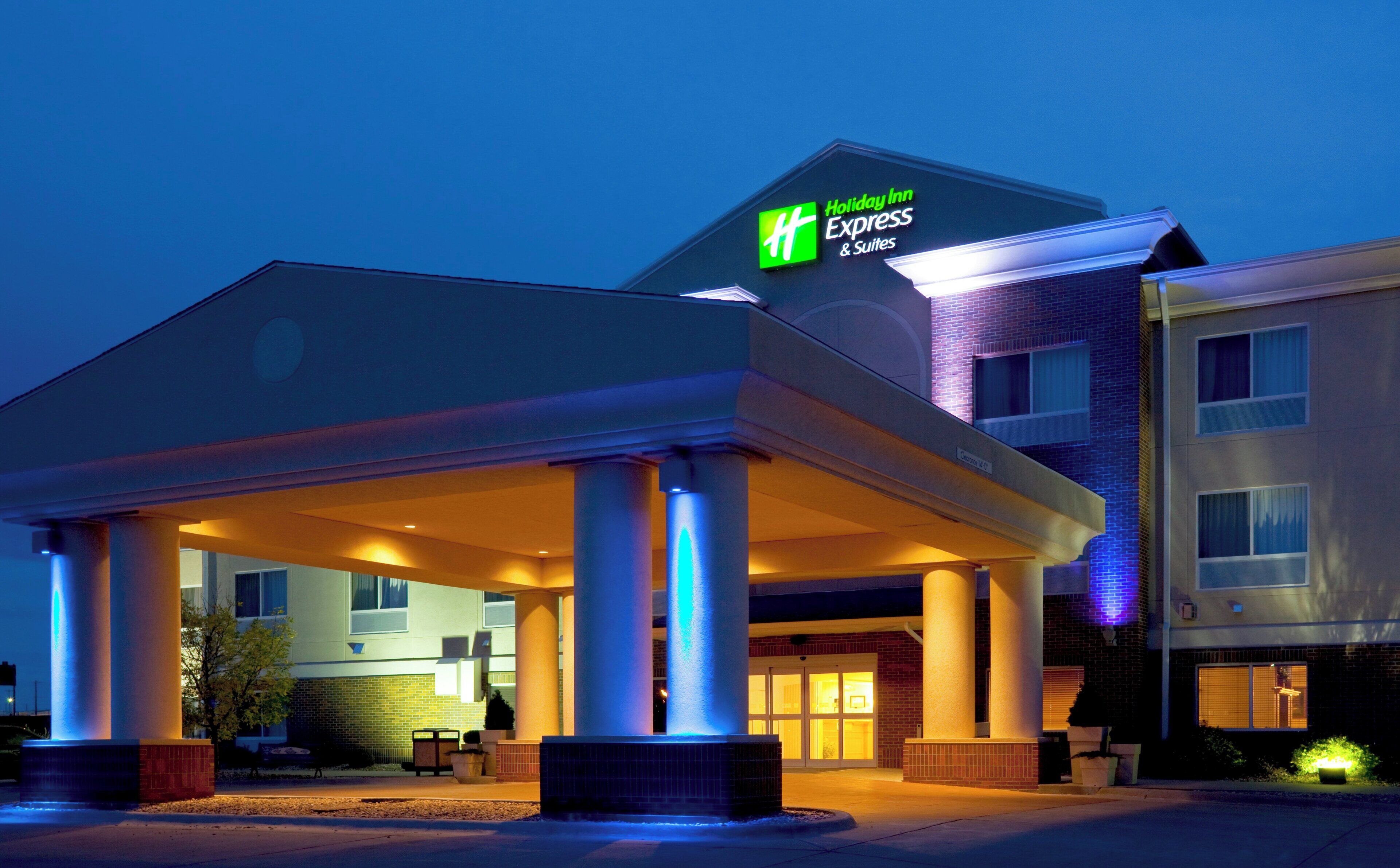 A Holiday Inn Express & Suites hotel with a covered entrance and a brick facade.