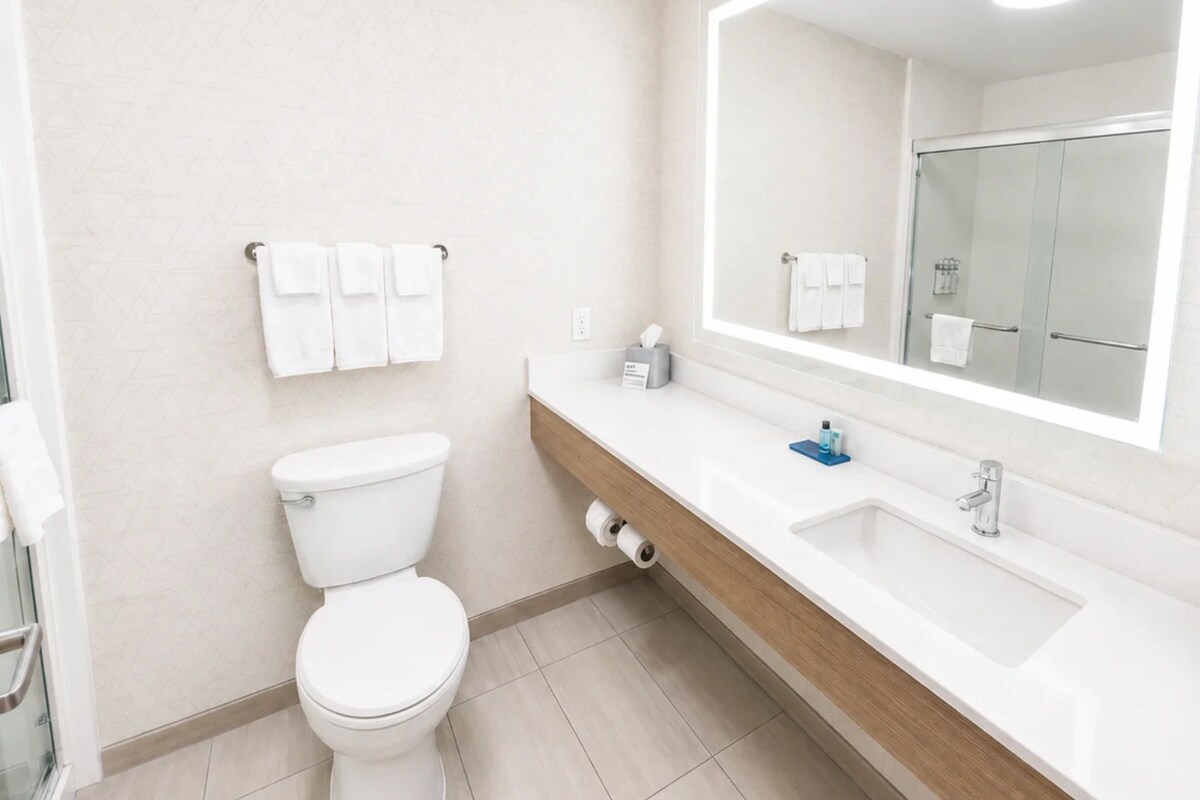 Une salle de bain moderne avec des toilettes, un lavabo et un miroir.