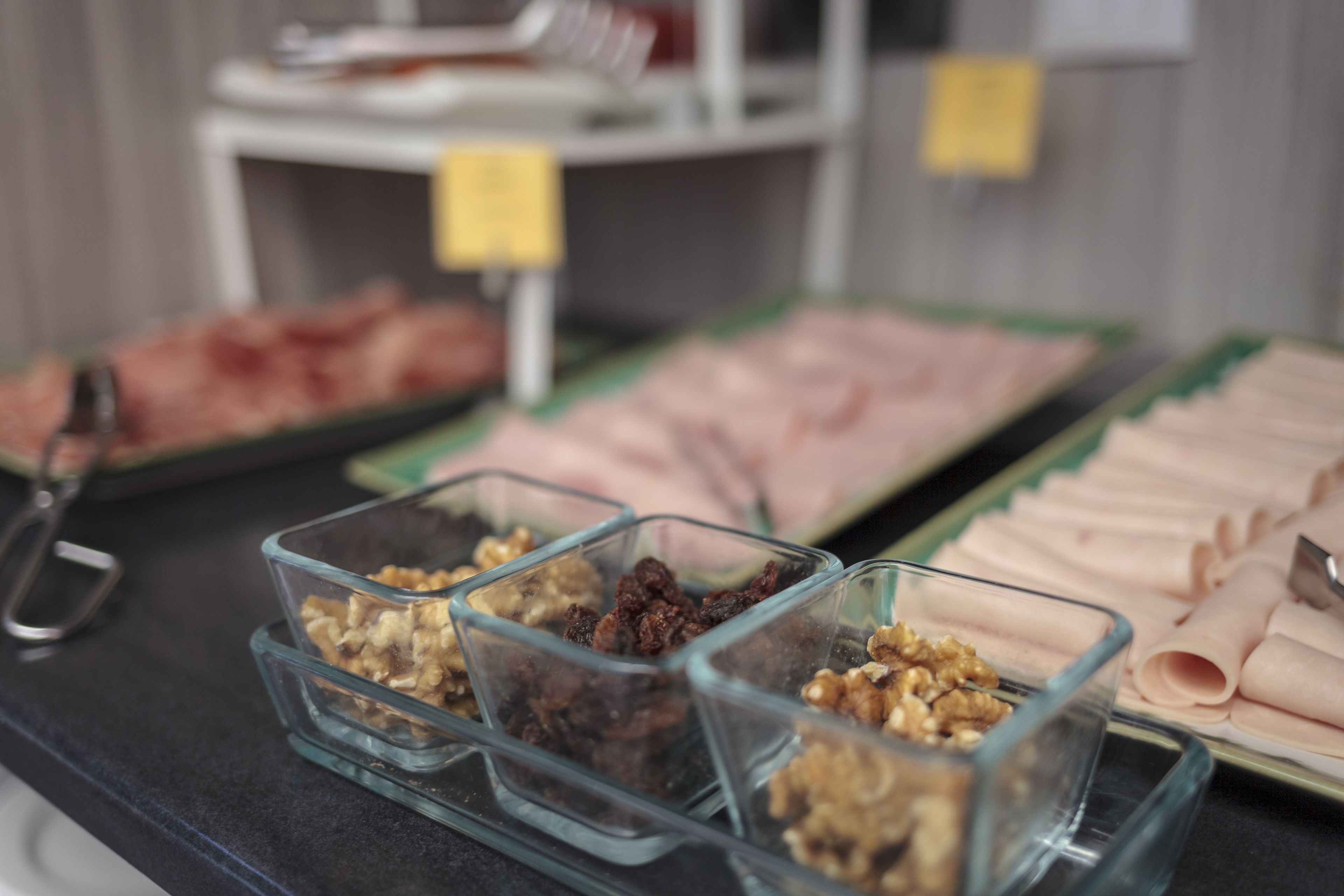 Una mesa de buffet con diversos alimentos, como carnes, nueces y frutas secas.