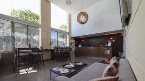 A modern hotel lobby with a dining area, a sofa, and a reception desk. - Hotel Salymar (San Fernando)