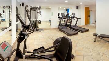 A gym with treadmills, elliptical machines, and weightlifting equipment.