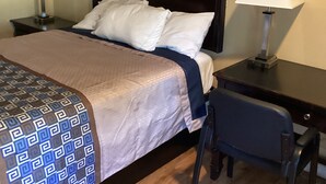 A hotel room with a bed, two bedside tables with lamps, a desk with a chair, and a wooden floor. - Town House Motel Chico (Chico)