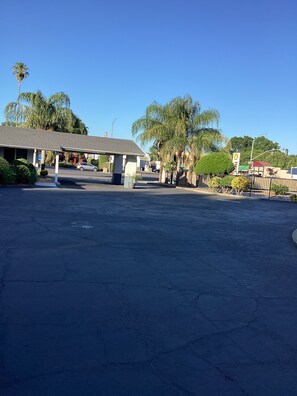 A parking lot with a gas station and a building with a covered area. - Town House Motel Chico (Chico)