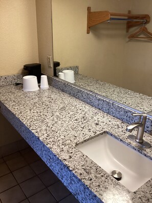 A bathroom with a granite countertop, a sink, and a mirror. - Town House Motel Chico (Chico)