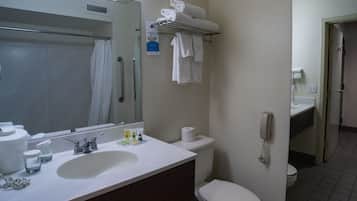 Een badkamer met een wastafel, spiegel, toilet en handdoekhouder.