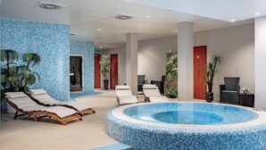 A swimming pool area with lounge chairs, a hot tub, and potted plants.