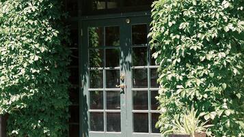 A building entrance with a green door and steps leading up to it.