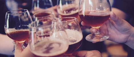 Un grupo de personas levantando copas de cerveza, probablemente en una reunión social o evento.