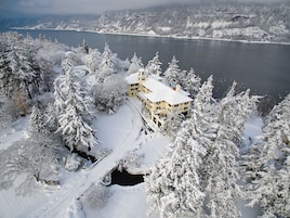 A snow-covered building with a lake in the background.