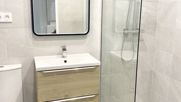 Standaard appartement | Badkamer | Een regendouche, gratis toiletartikelen, een haardroger, handdoeken