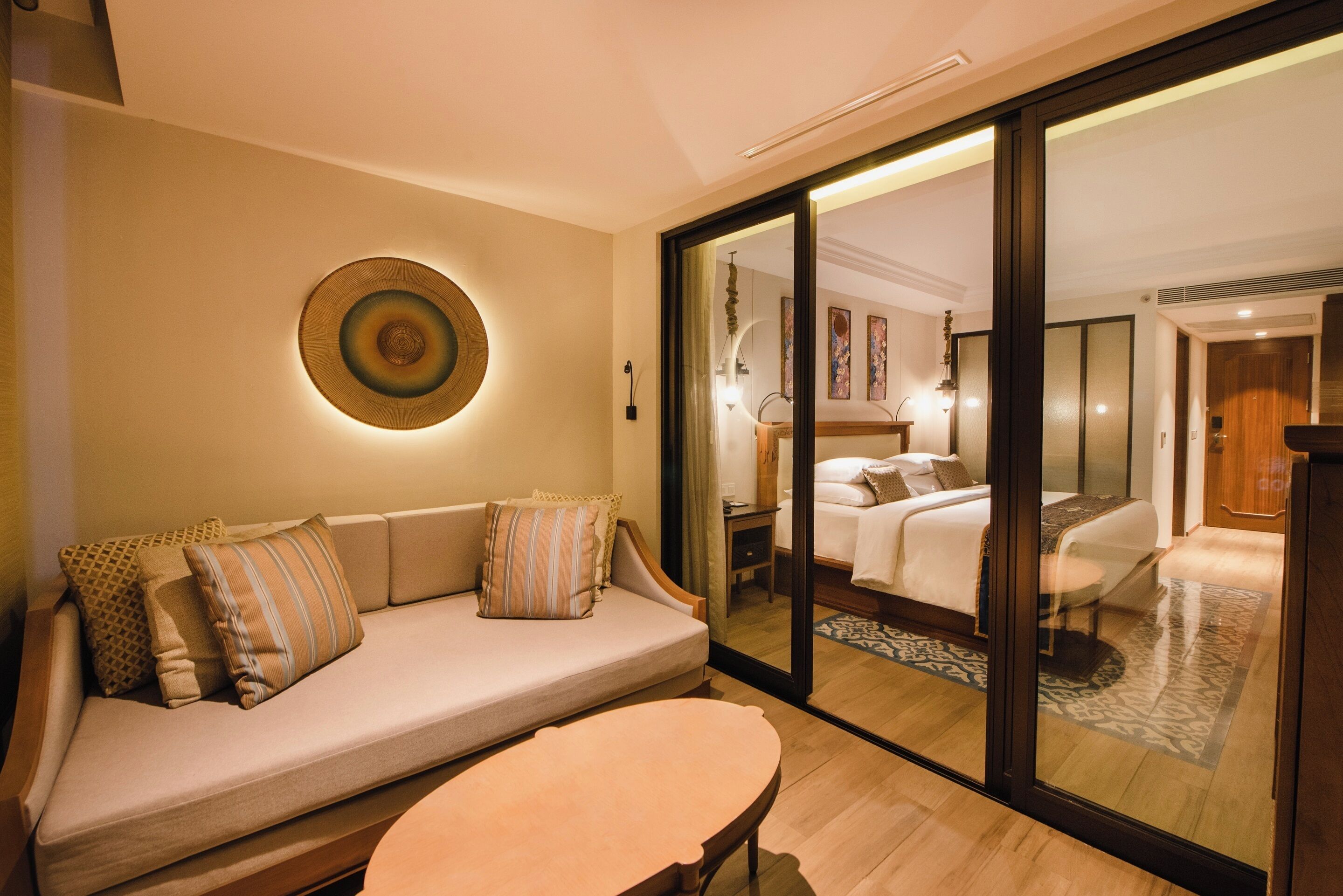 A modern hotel room with a sofa, a small table, and a bed.