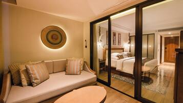 A modern hotel room with a sofa, a small table, and a bed.