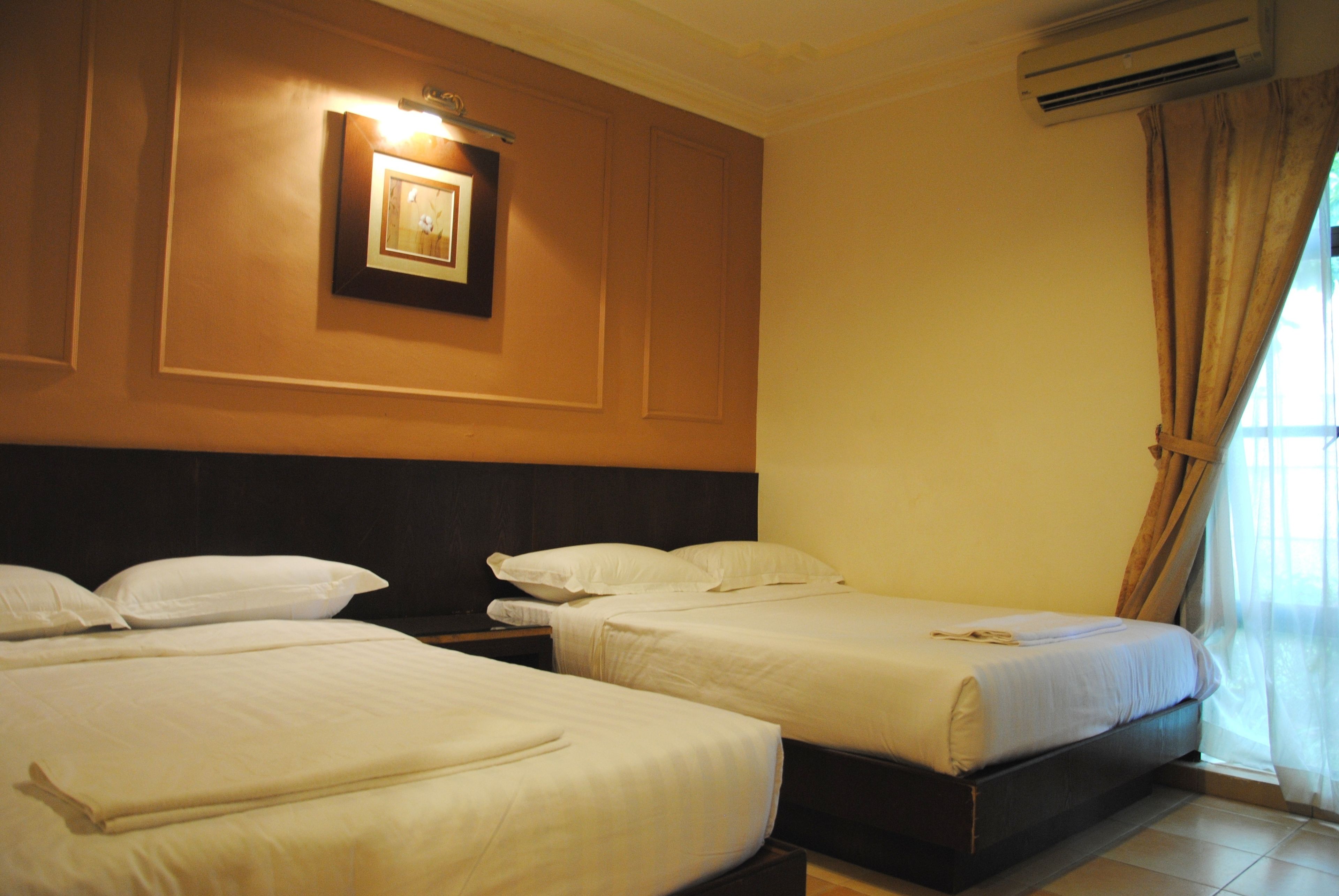 A hotel room with two beds, a framed picture on the wall, and an air conditioning unit.
