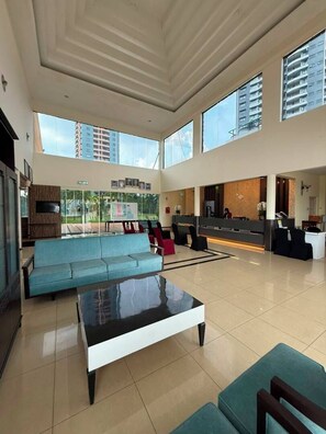 A spacious lobby with a reception desk, seating area, and large windows offering views of the outside. - A'Famosa Resort (Alor Gajah)