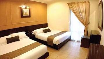 A hotel room with two beds, a nightstand, a desk, and a window with curtains.