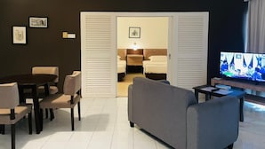 A modern living room with a dining table, sofas, a TV, and a ceiling fan. - A'Famosa Resort (Alor Gajah)