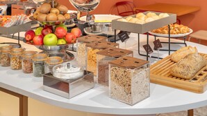 Een buffet met diverse gerechten, waaronder fruit, noten en gebak.