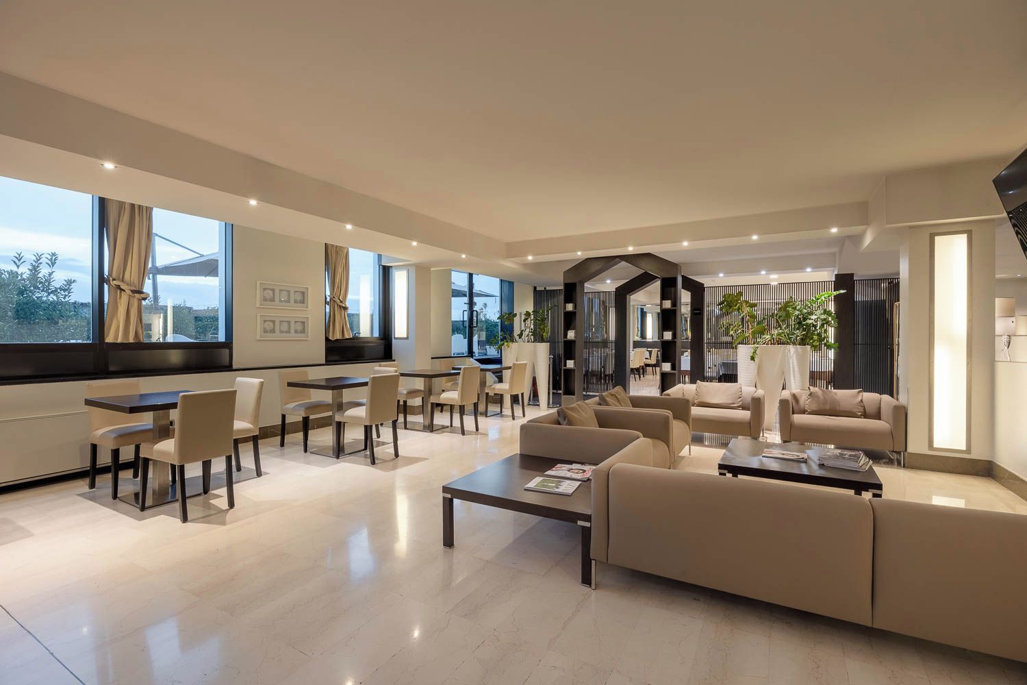A spacious living area with a dining set, sofas, and a coffee table.