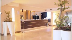 A reception area with a counter, a potted plant, and a modern interior design. - Golf Hotel Milano (Opera)