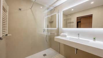 Un bagno moderno con doccia vetro, mobile lavabo bianco e porta asciugamani.
