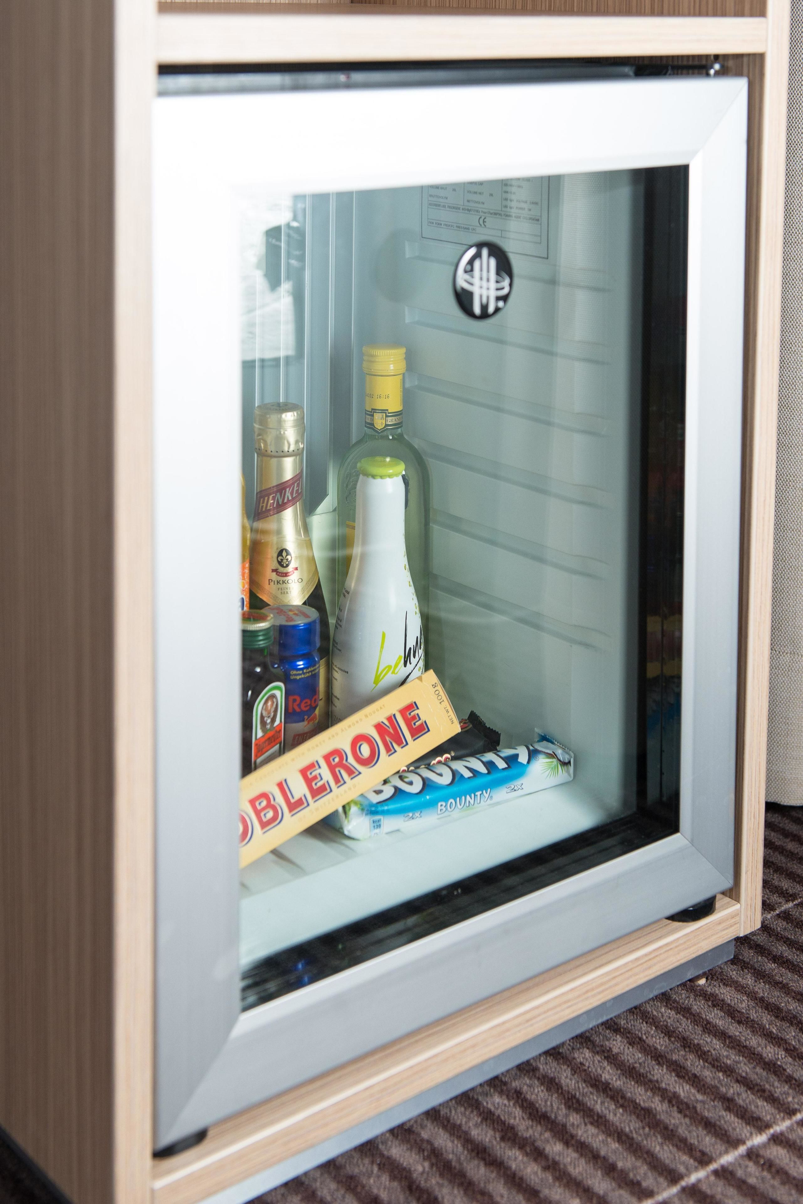 Eine Vitrine mit verschiedenen Spirituosenflaschen und einem markenbezogenen Artikel.