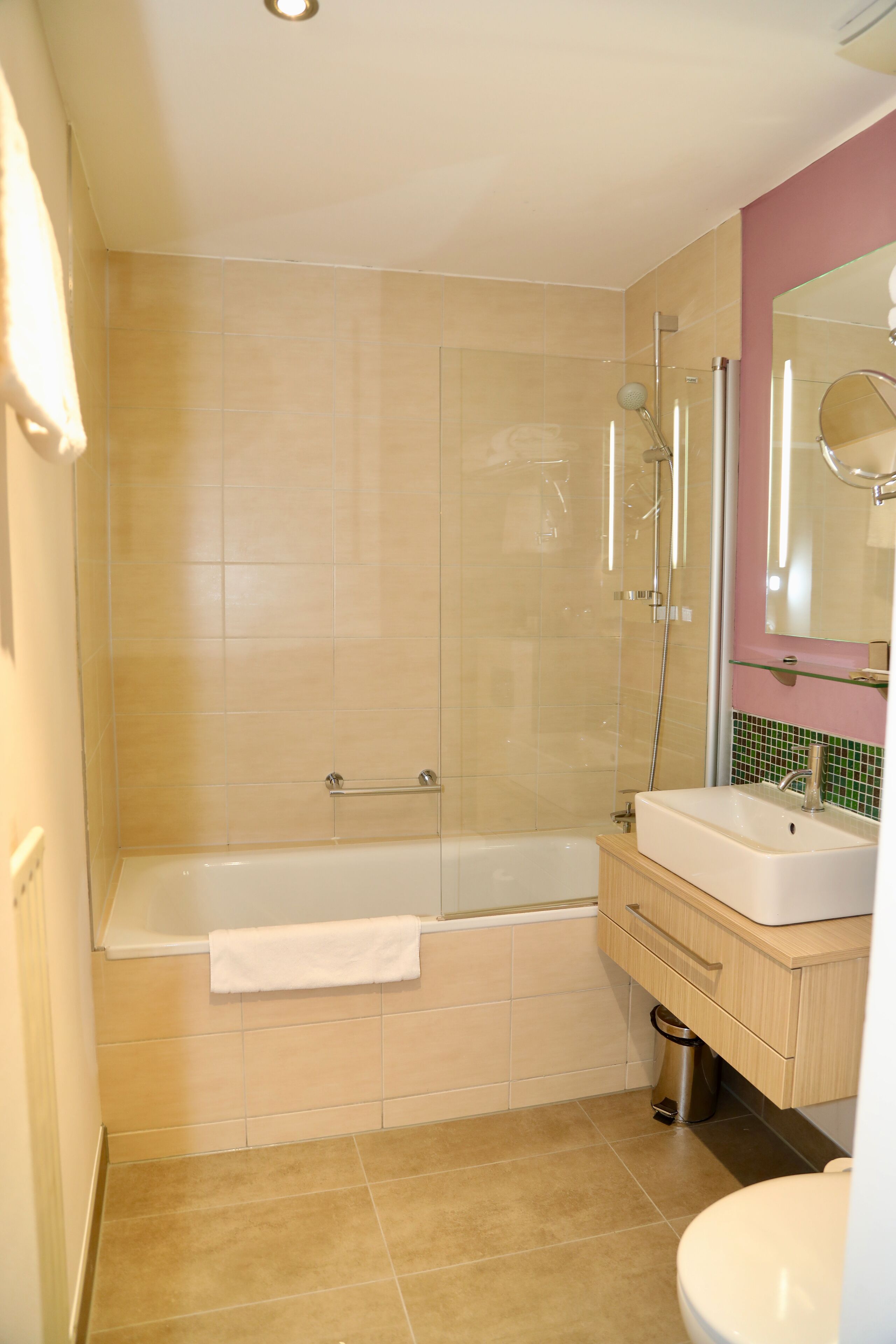 Een badkamer met een bad, wastafel en toilet.