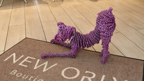 A reception area with a brown doormat reading "NEW ORLY Boutique-Hotel" and a purple knitted sculpture on the floor. - New Orly (Munich)