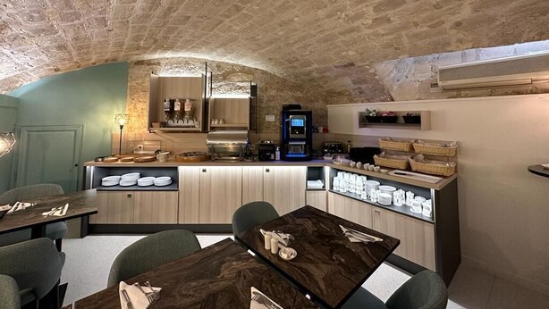 A rustic stone ceiling, a kitchen with modern appliances, and a dining area with wooden tables and chairs. - Hotel France Albion (Paris)