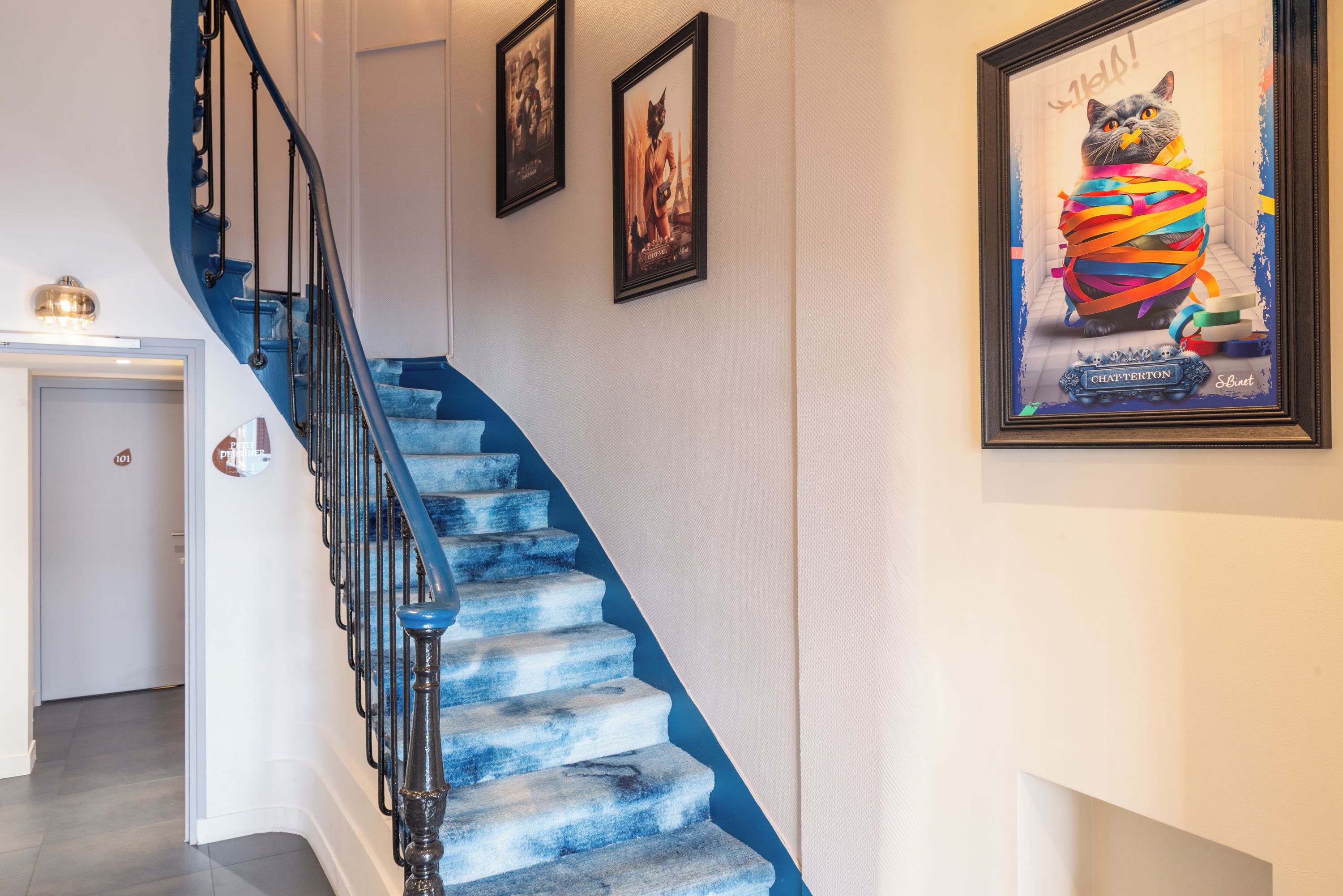 A staircase with blue steps and black railings, leading to a door marked '101'.