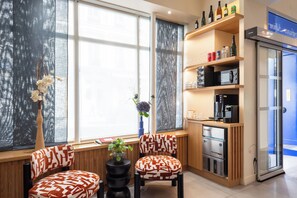 Un rincón de descanso con dos sillones, una mesa y un jarrón decorativo.