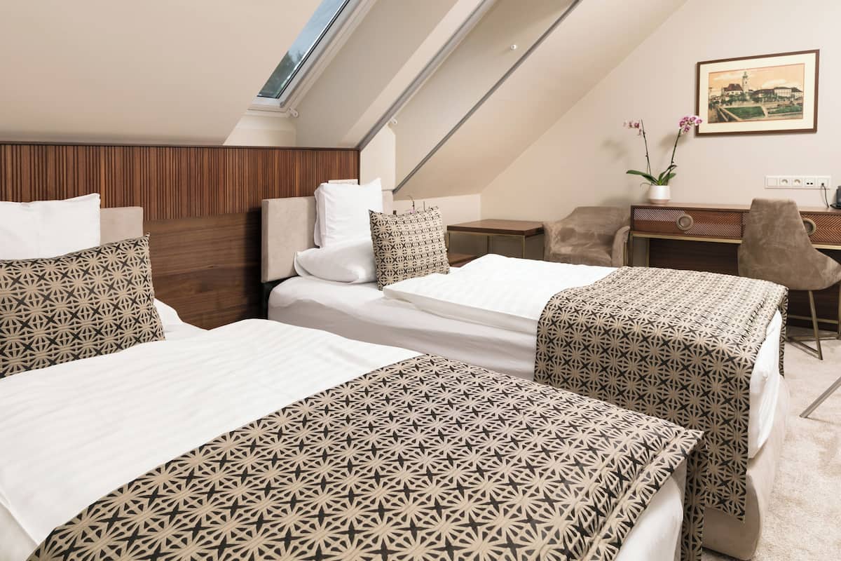 Una habitación de hotel con dos camas, un escritorio y una silla.
