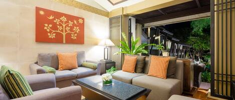 A modern living room with a sofa, armchairs, a coffee table, and a decorative wall piece.