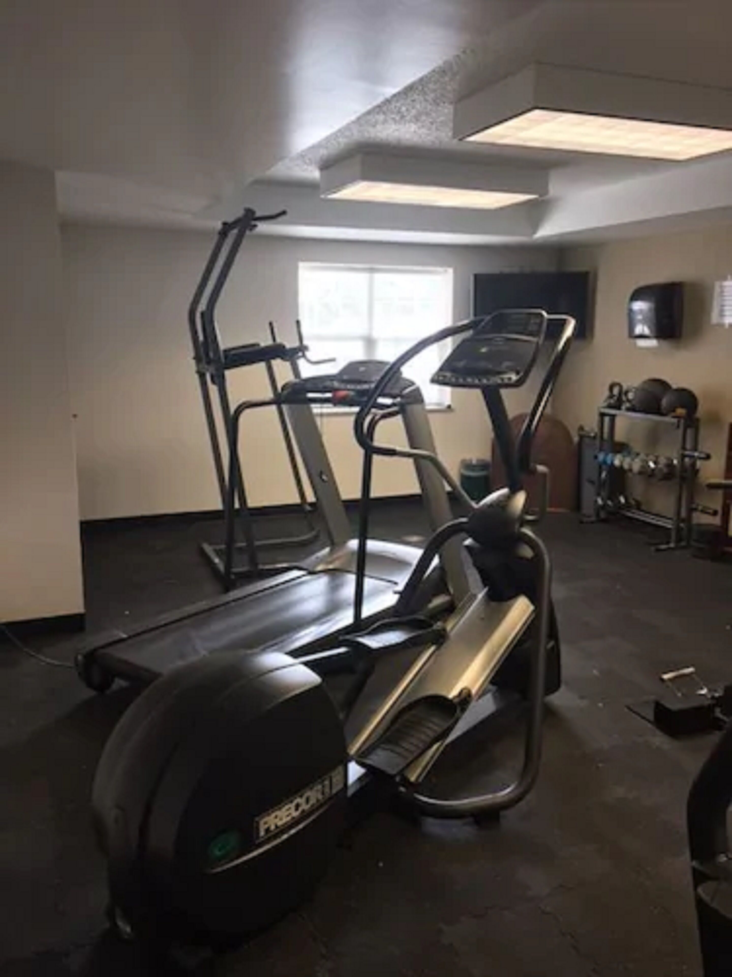 Un gimnasio con cintas de correr y una máquina elíptica.