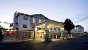 A hotel with a covered entrance, a sign reading "HOST All Suites," and a parking lot. - Host Inn All Suites (Wilkes-Barre)