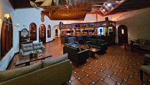 A bar area with a high ceiling, wooden beams, and a ship's wheel decoration. - Rio Perlas Thermal Resort & Spa (Dulce Nombre)
