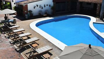 Una piscina al aire libre, tumbonas
