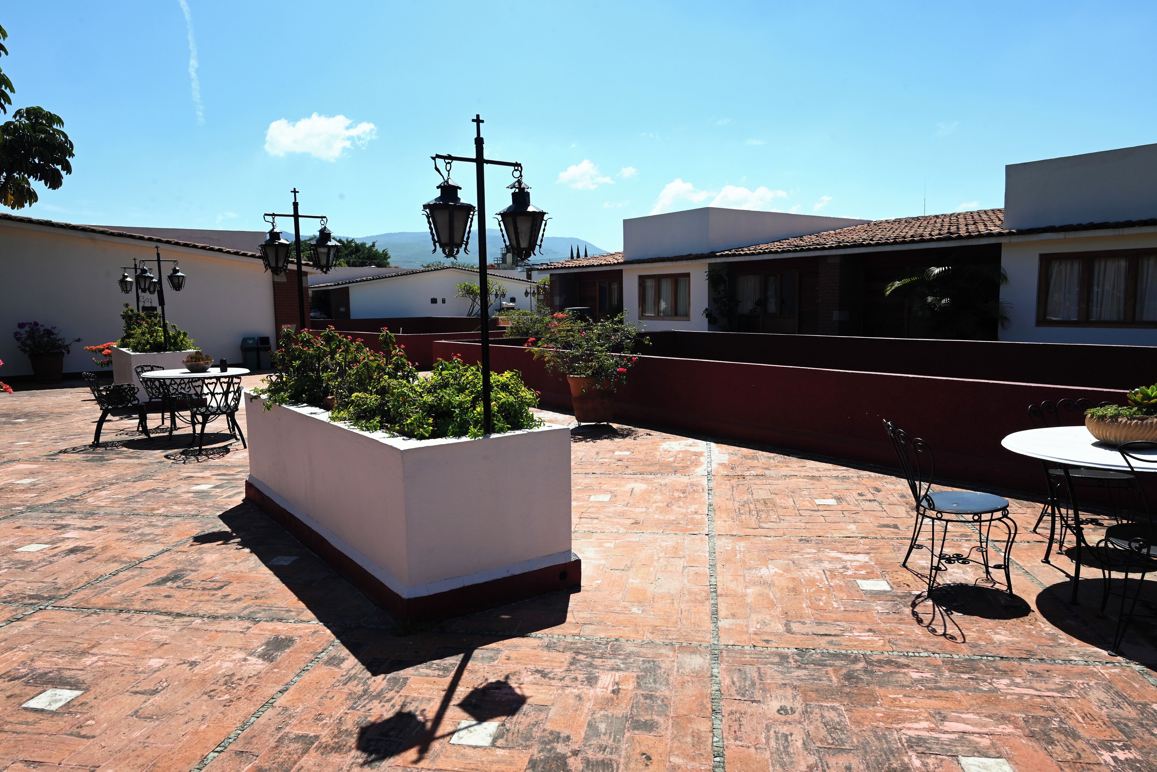 A patio area with a white planter, outdoor furniture, and a view of buildings in the background.