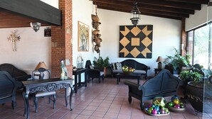 Un patio acogedor con muebles rústicos, un muro decorativo y vistas al exterior.