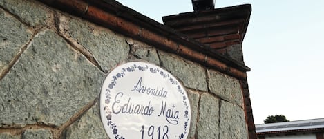 A stone wall with a plaque reading "Avenida Eduardo Mata 1918".