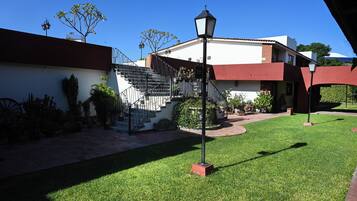 A courtyard with a staircase, a lamp post, and a building with a red and white facade.