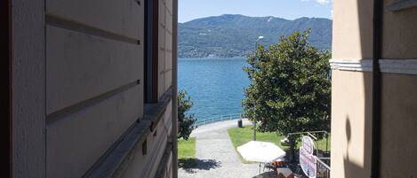 A narrow balcony with a view of a lake and mountains.