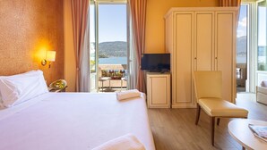 Una habitación de hotel con cama, televisión, armario, silla y mesa.