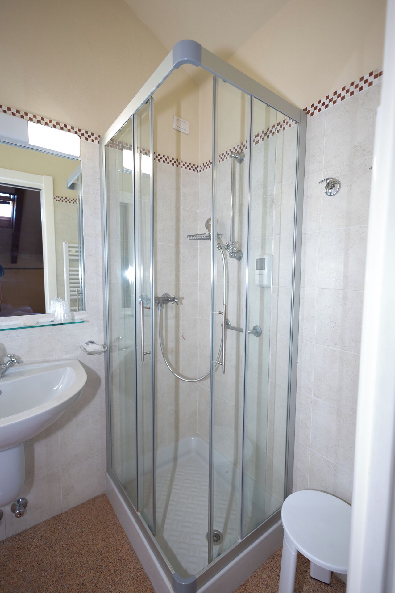 A bathroom with a glass-enclosed shower, a sink, and a toilet.