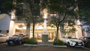 A building with a reception desk, parked cars, and a paved entrance area. - Turotel Morelia (Morelia)