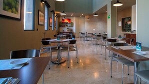 A spacious dining area with multiple tables and chairs, large windows, and pendant lighting. - Turotel Morelia (Morelia)